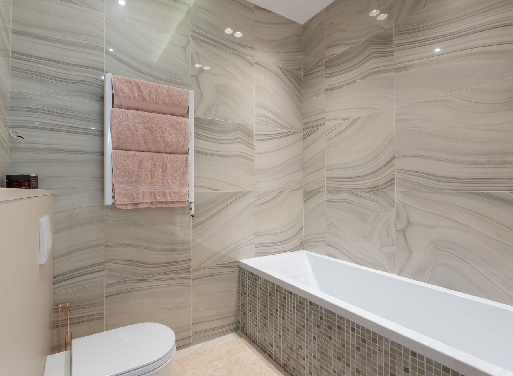 Contemporary bathroom interior with white marble tile walls and warm natural light